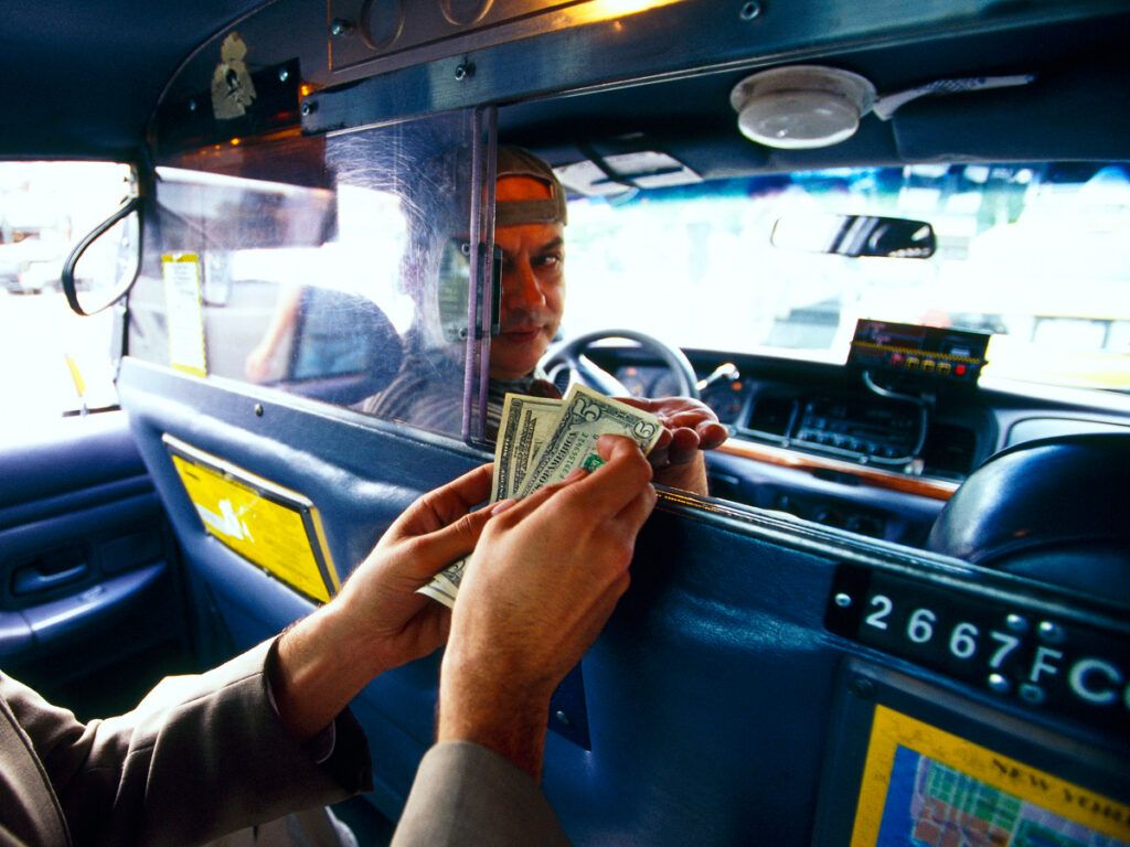 Taxi rider handing over cash payment