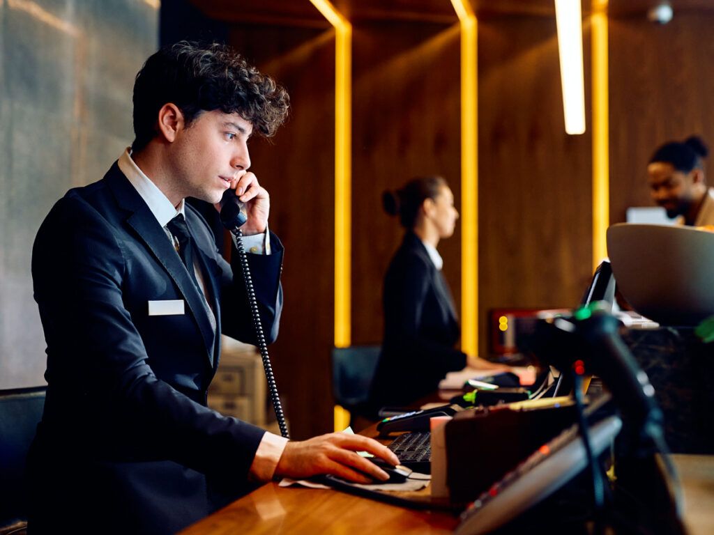 Hotel front desk employee speaking on phone