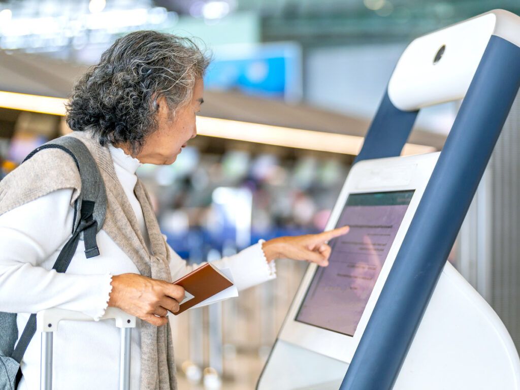 Passenger using automated check-in kiosk at airport