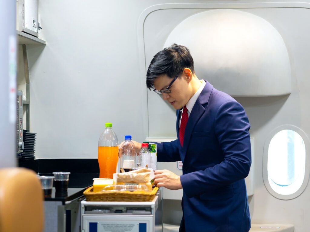 Flight attendant preparing beverages in galley