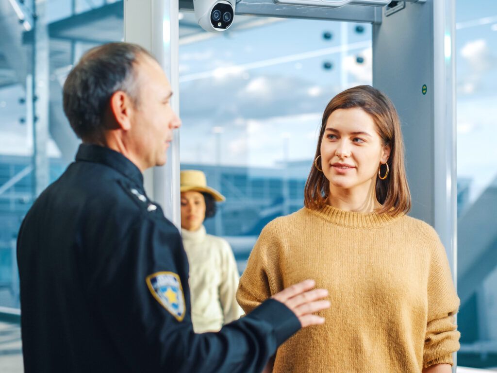 Traveler talking to security agent at airport checkpoint