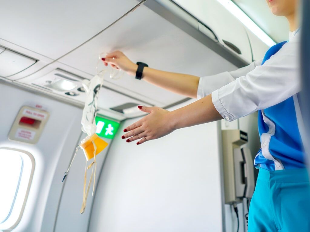 Flight attendant performing safety demo