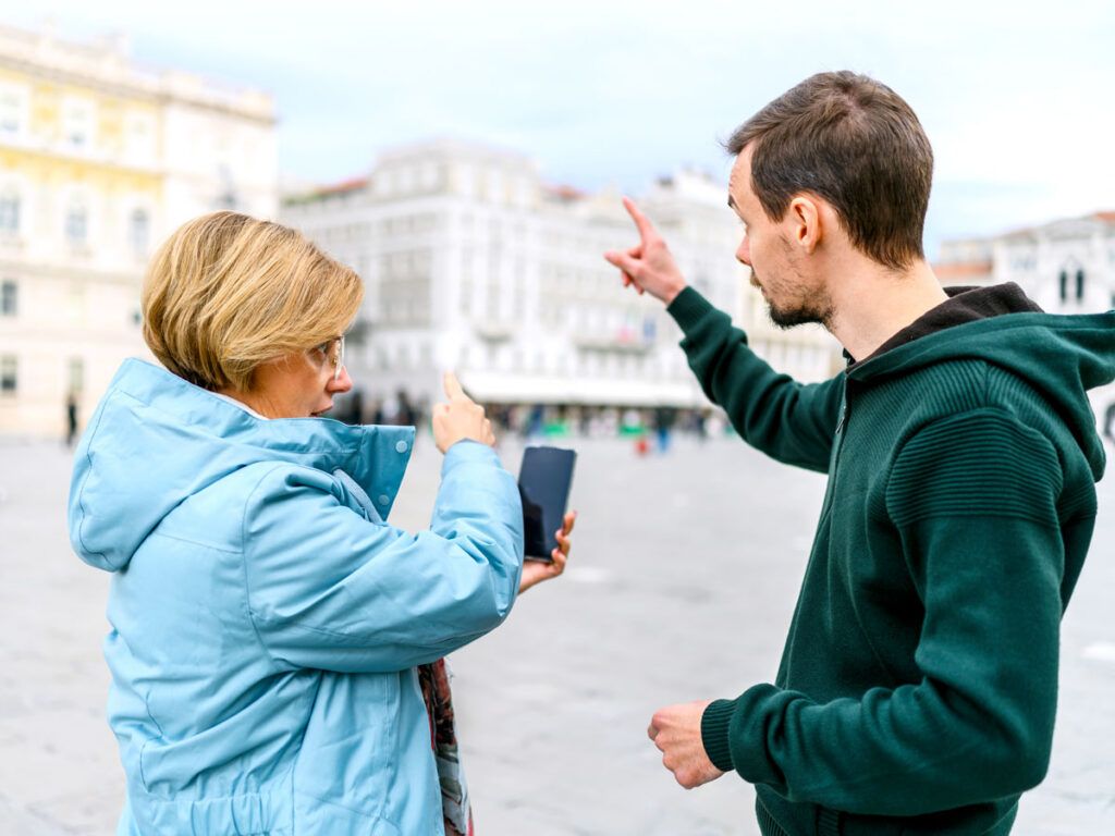 Person giving directions to tourist in city square