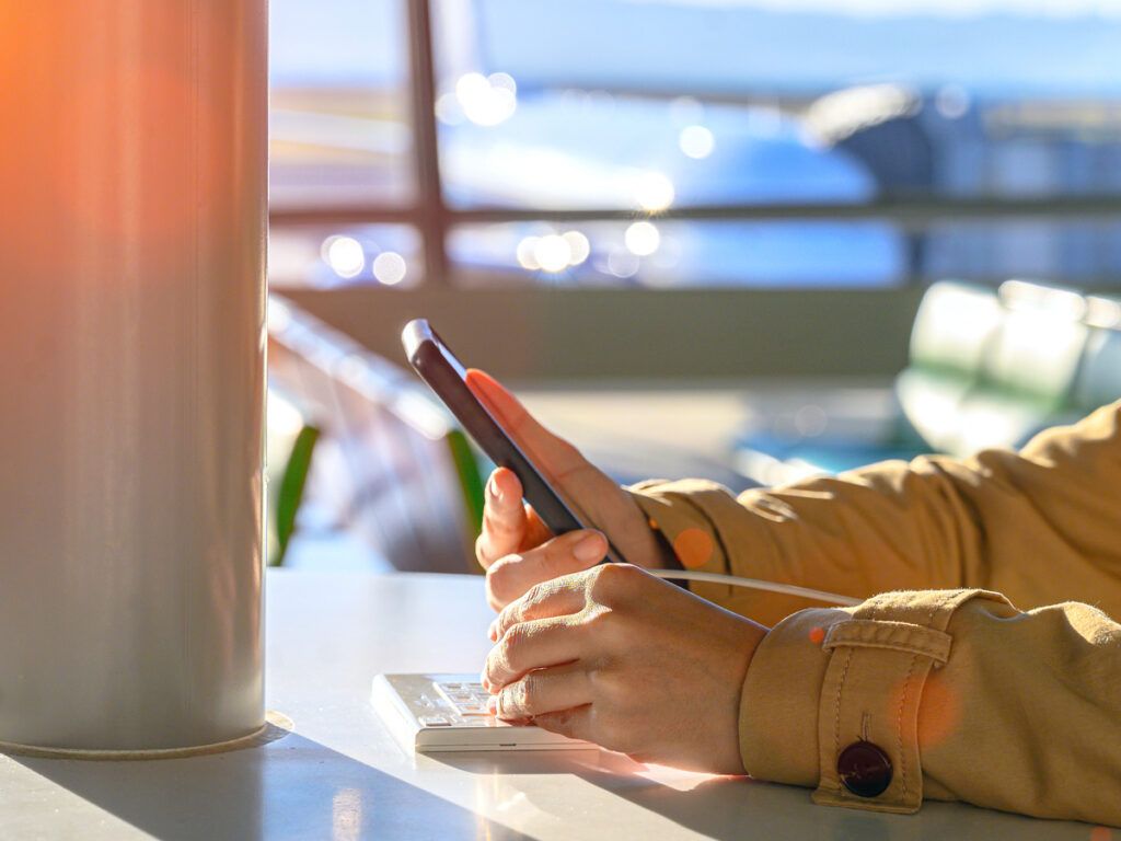 Traveler using phone in airport terminal