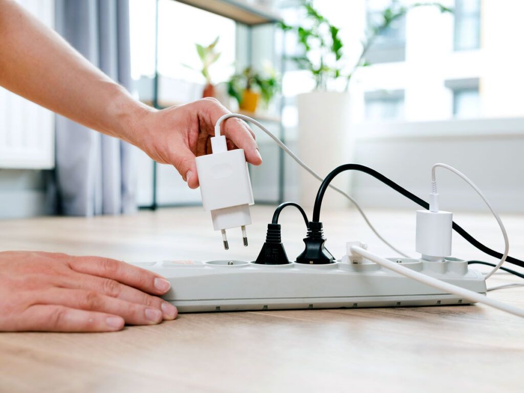 Person plugging charger into power strip