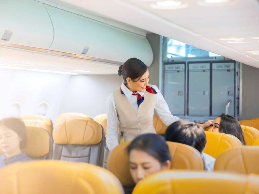 Flight attendant checking on passenger