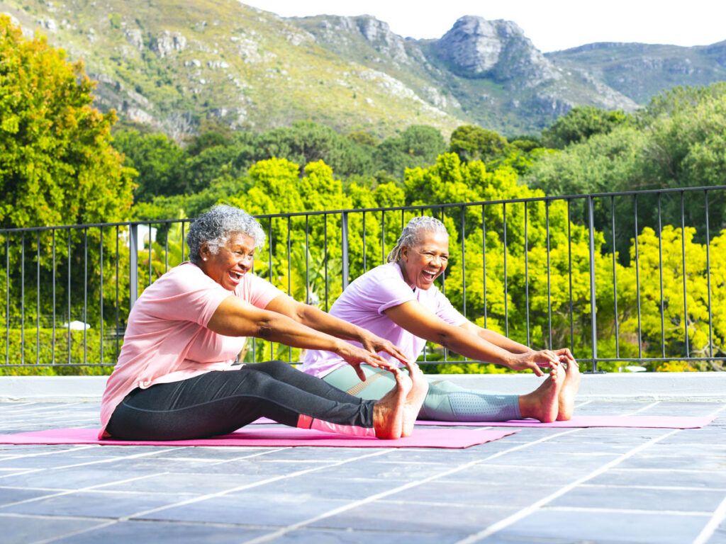 Two women doing yoga on a patio