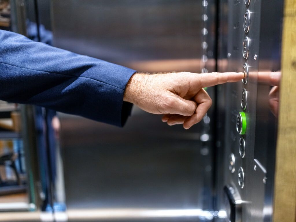Hotel guest pushing elevator button