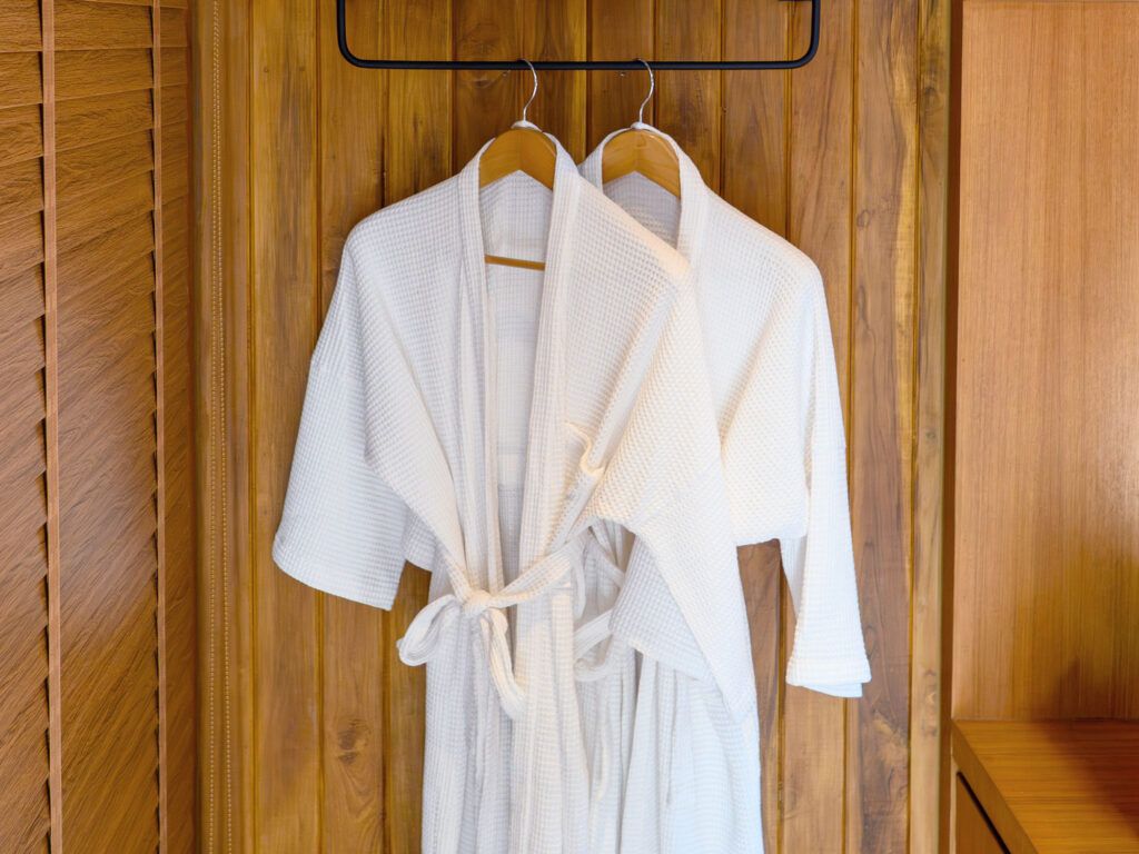 Bathrobes hanging on a door in a hotel room