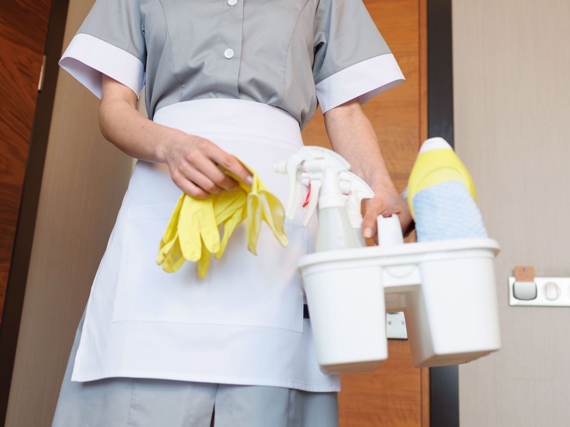 Hotel housekeeper with cleaning supplies