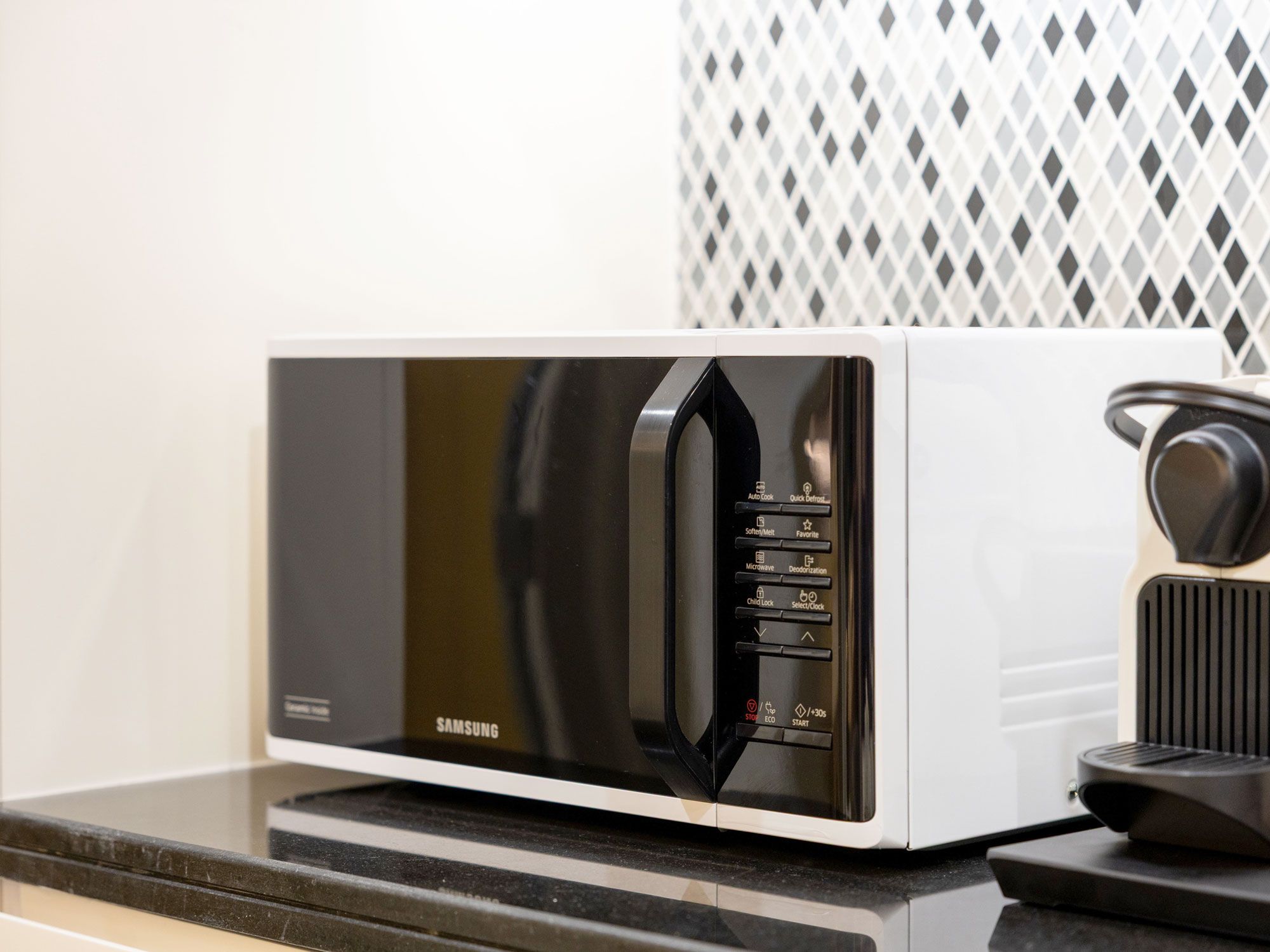 Microwave on counter next to espresso machine