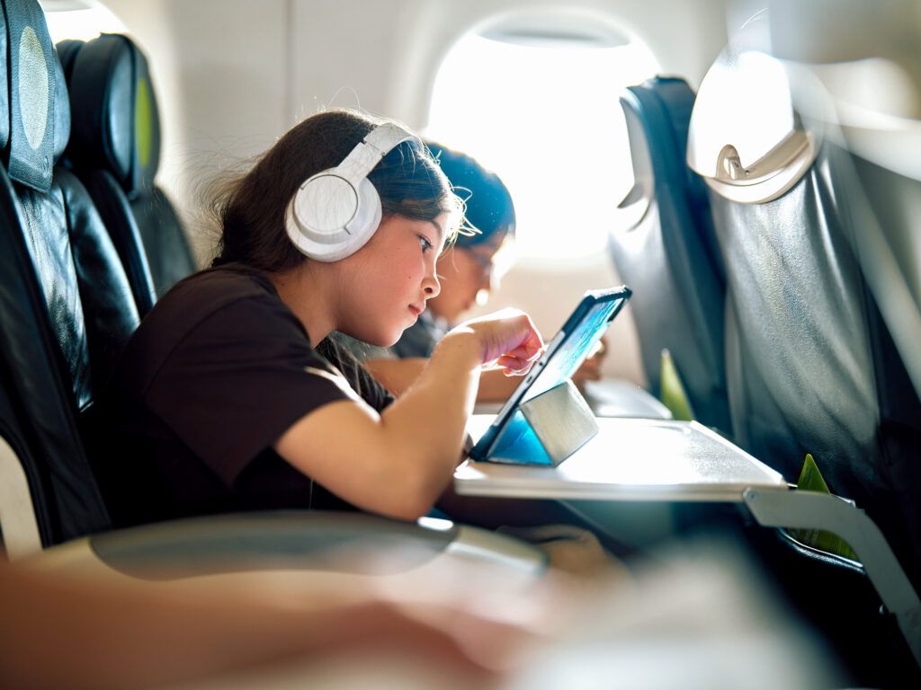 Girl playing on a tablet during a flight