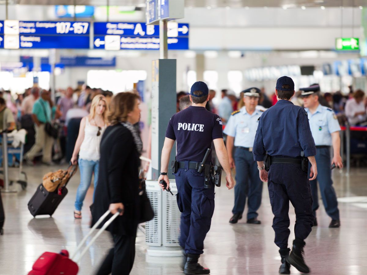 Police officers walking among passengers in airport