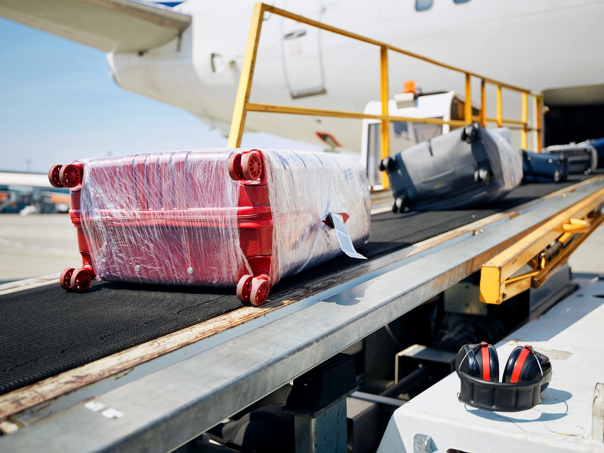 Bags on conveyor belt being loaded on plane