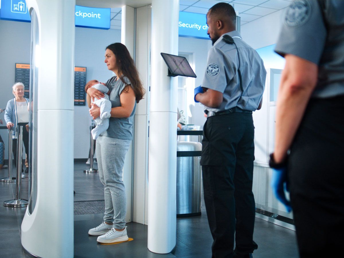 Mother and child in metal detector at airport security checkpoint