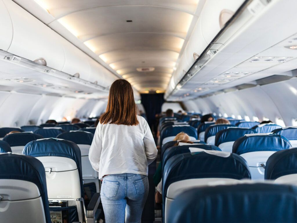 Woman walking the aisle on an airplane