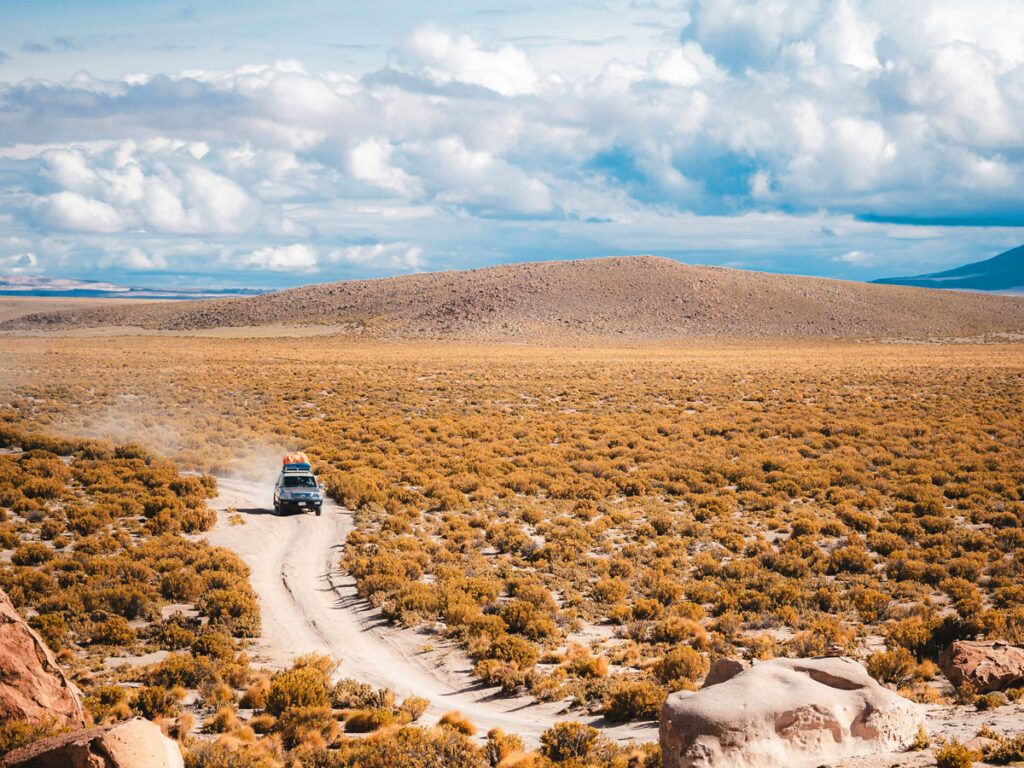 Car driving a dirt road in the desert