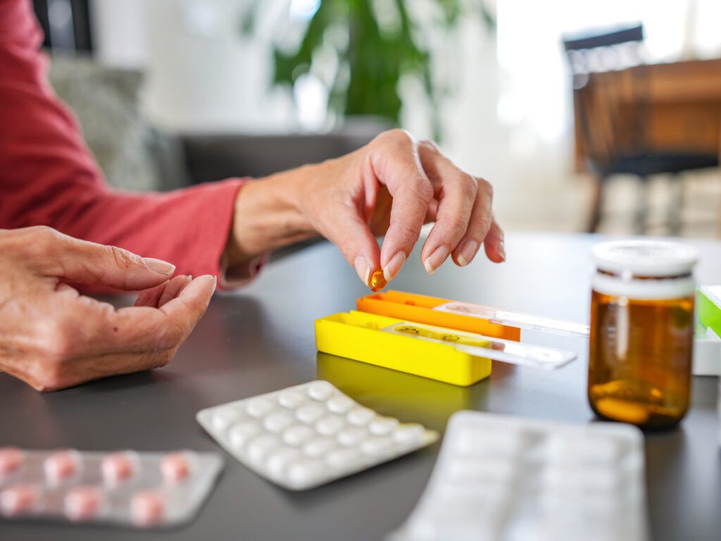 Woman putting pills in a medication organizer