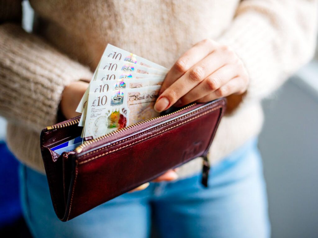 Woman pulling cash out of a wallet
