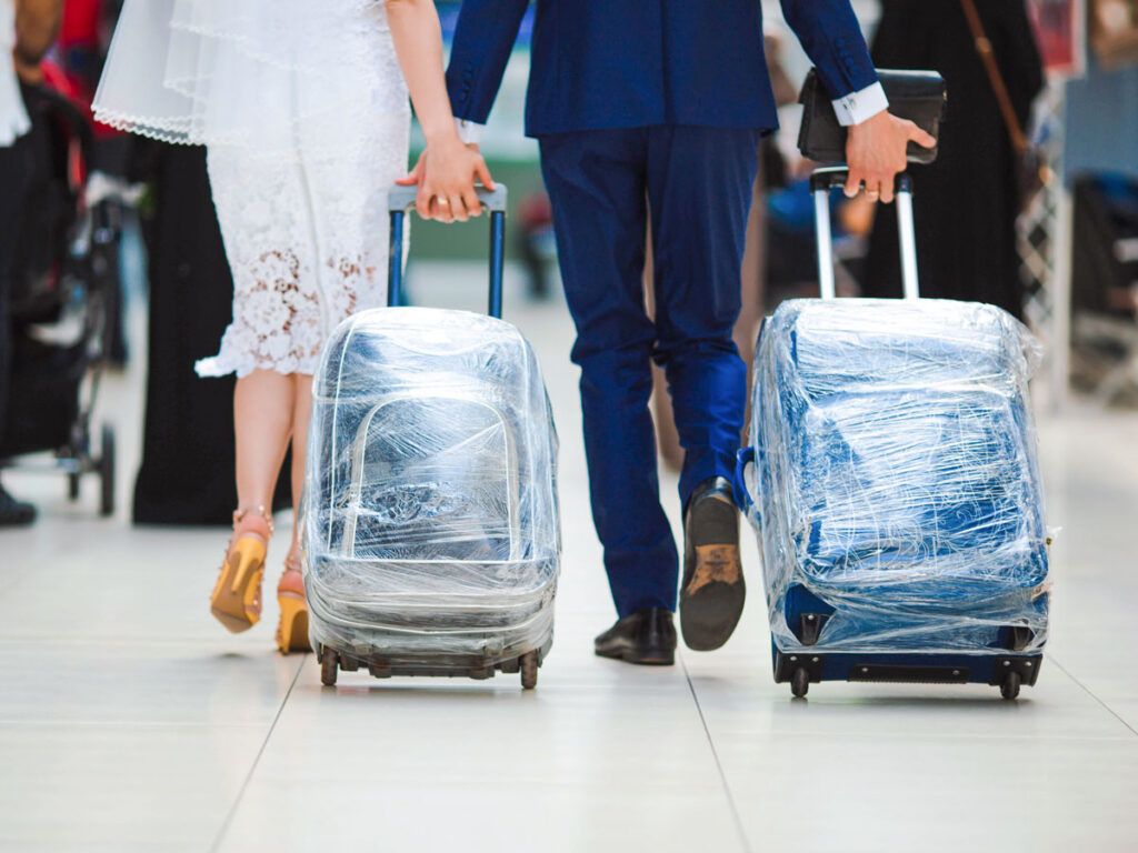 Man and woman rolling their luggage