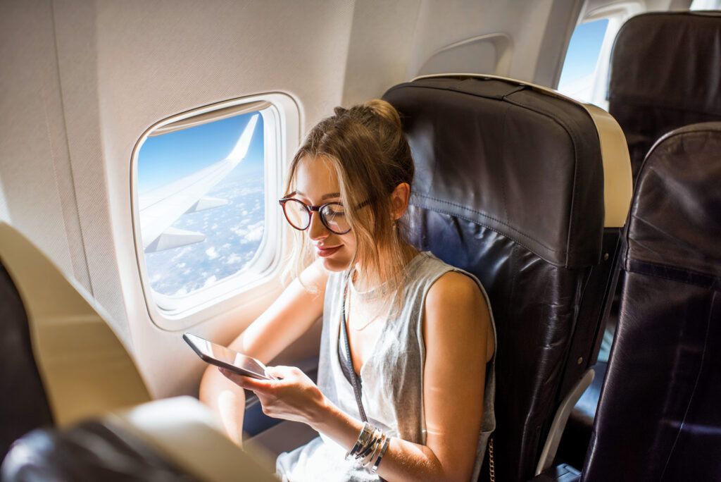 Woman looks at her phone during a flight