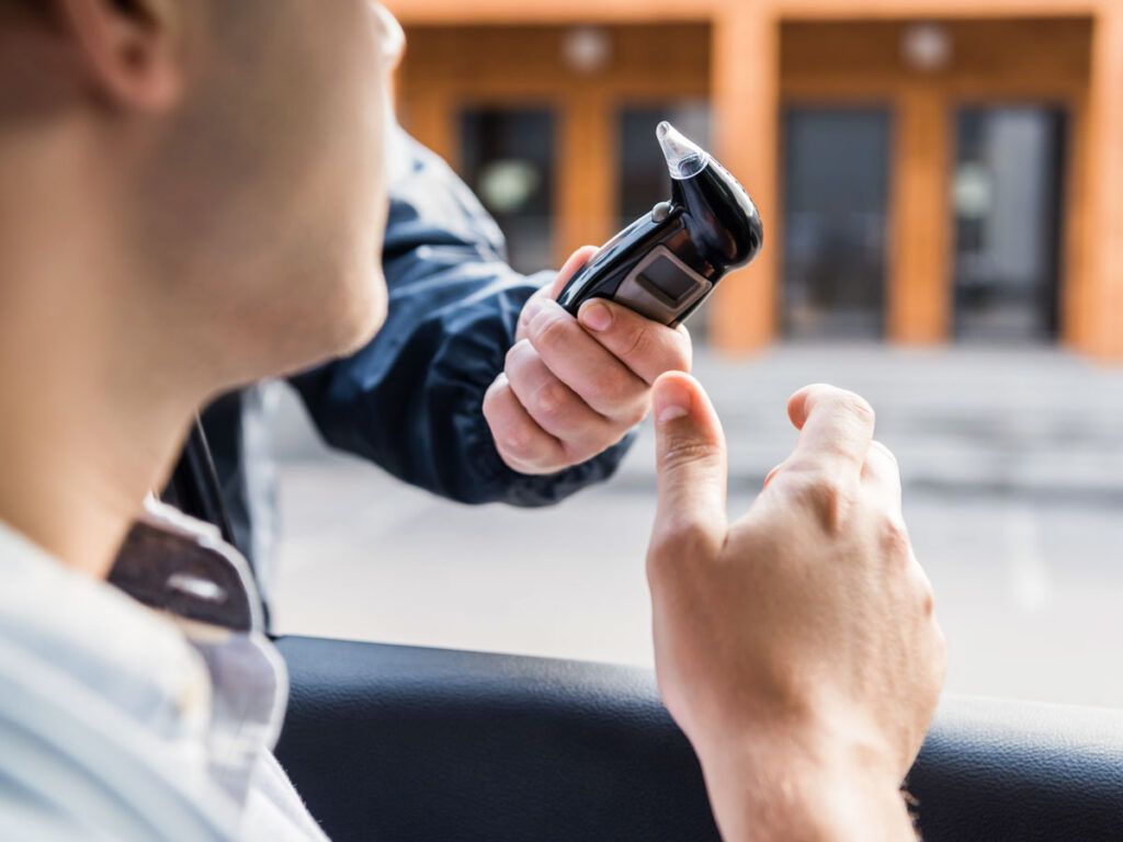 Man blowing into a breathalyzer