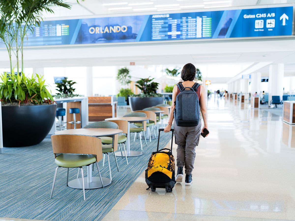 Traveler rolling bag through Orlando International Airport