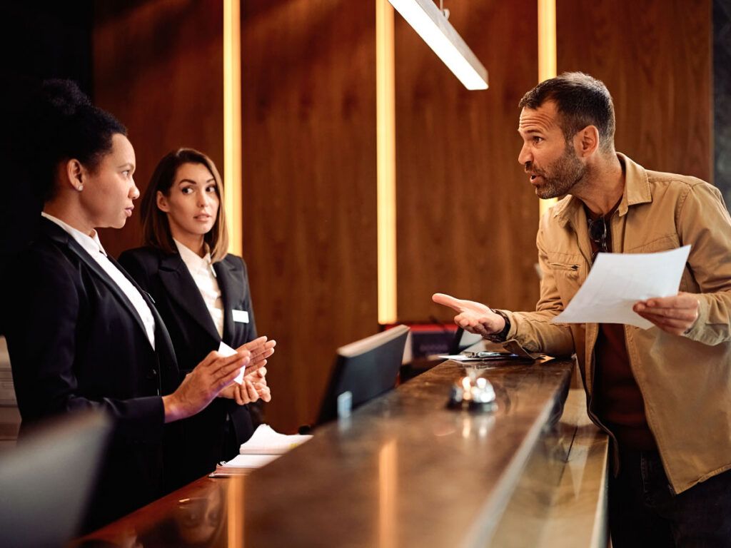 Man asking a question about his bill at a hotel desk