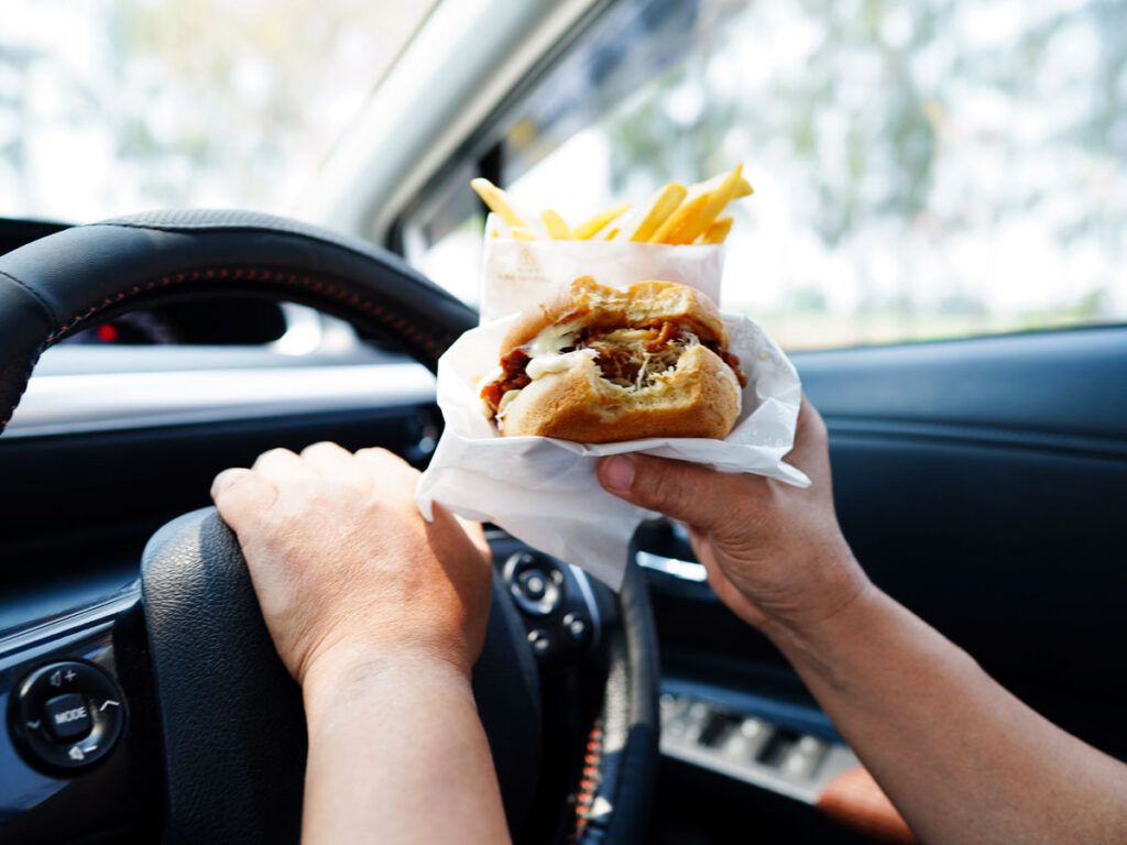 Driver eating a burger at the wheel