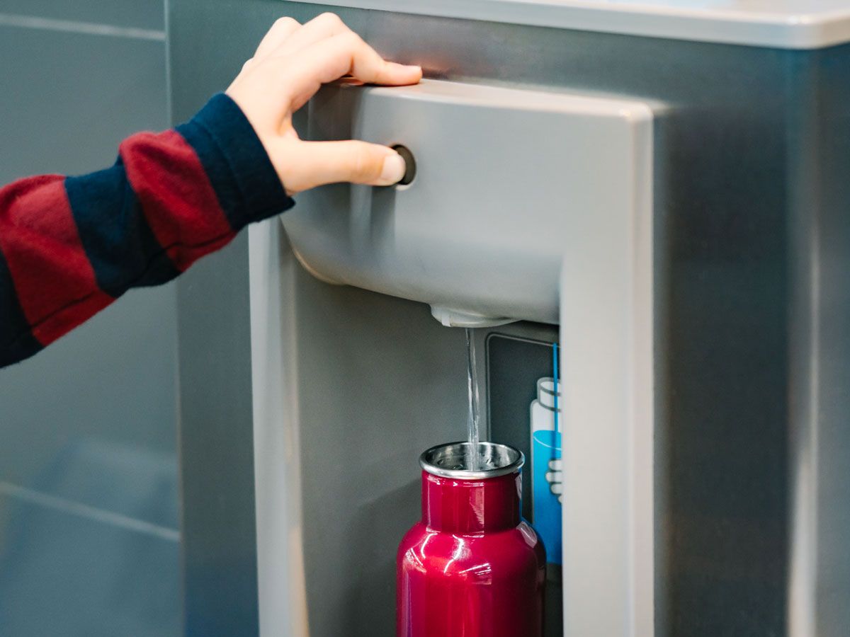 Person refilling water bottle at refilling station