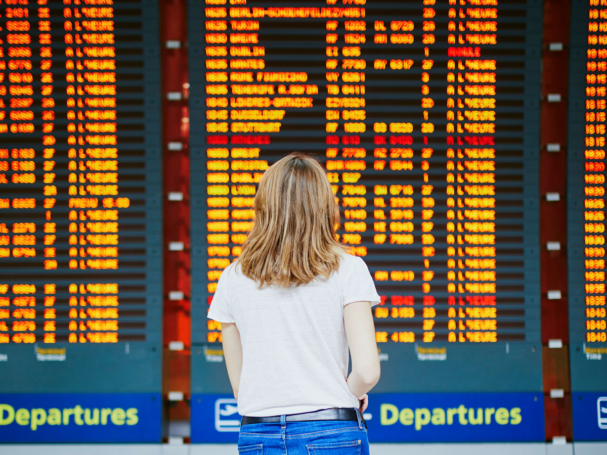 Woman reads the flight display board at the airport