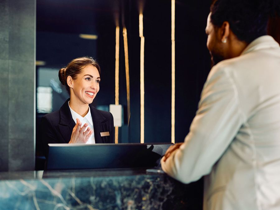 Hotel receptionist talking to a guest at the front desk