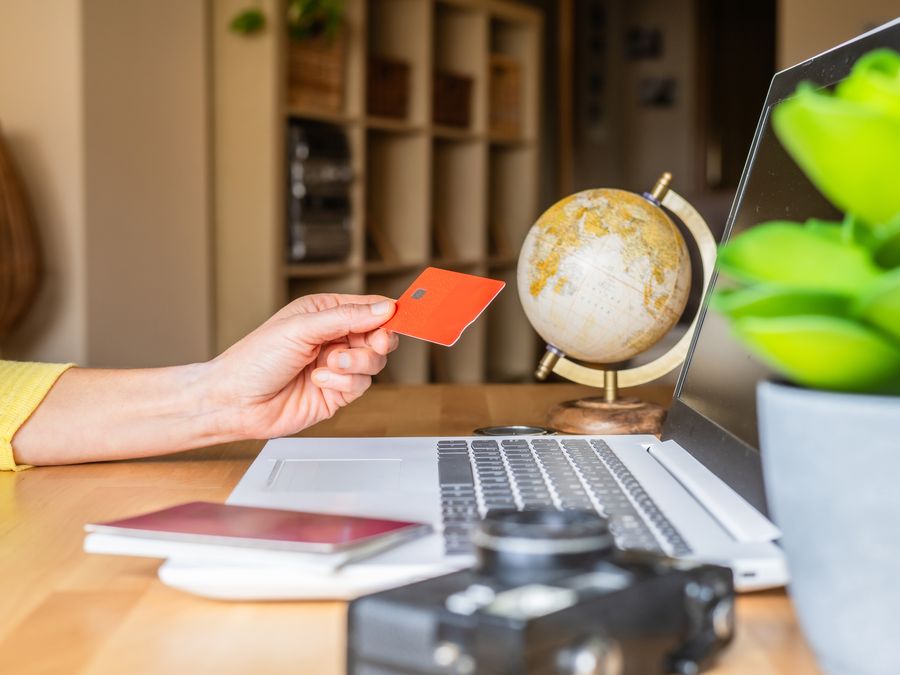 Woman booking a trip online using a laptop and her credit card